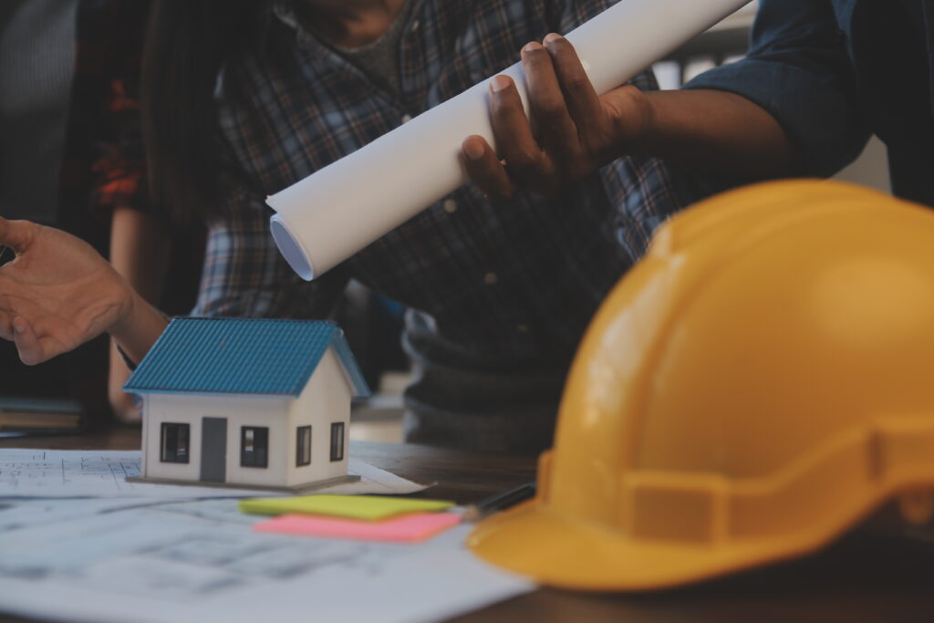 The Most Valuable Person on a Development Team Usually Isn't Who You Think a team of construction engineers talks to managers and construction workers at the construction site. quality inspection, work plan, home and industrial building design project